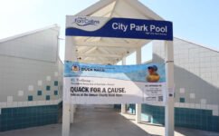 Large Duck Race Banner hanging Outside City Park Pool