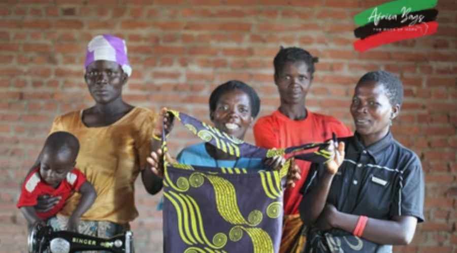 Africa Bags employees showing one of their hand-crafted bags